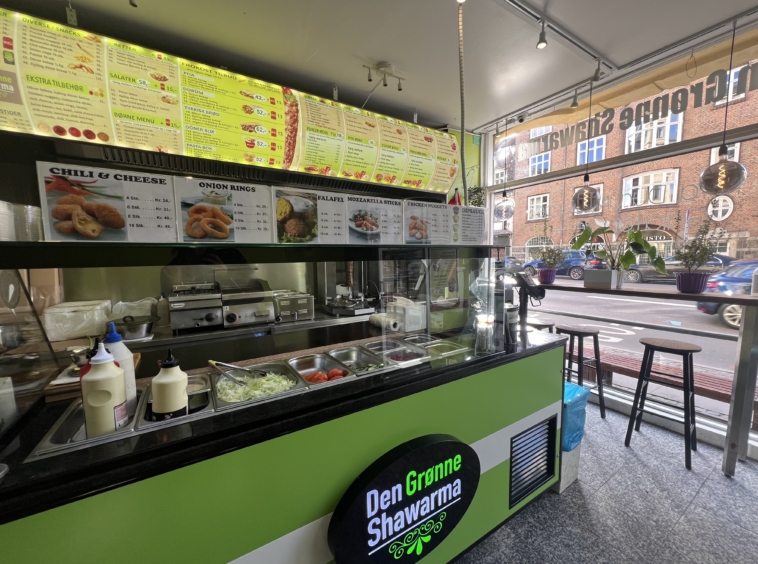 Interiør af Den Grønne Shawarma med kundeområde og menu oversigt