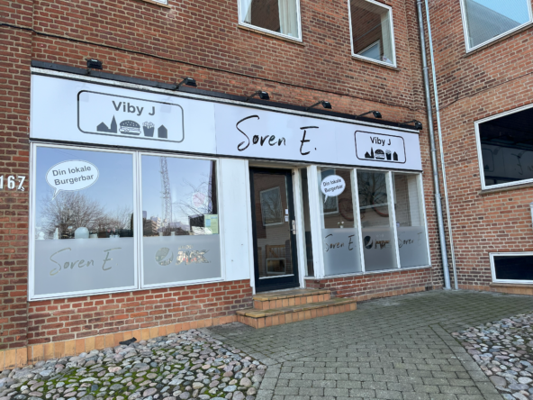 Udvendigt billede af burgerbaren 'Viby J' i en toetagers murstensbygning med store vinduer og navneskilte