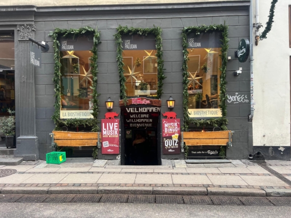 Facade af Rhino Bar København med dekorative grønne ranker og indgangslys.