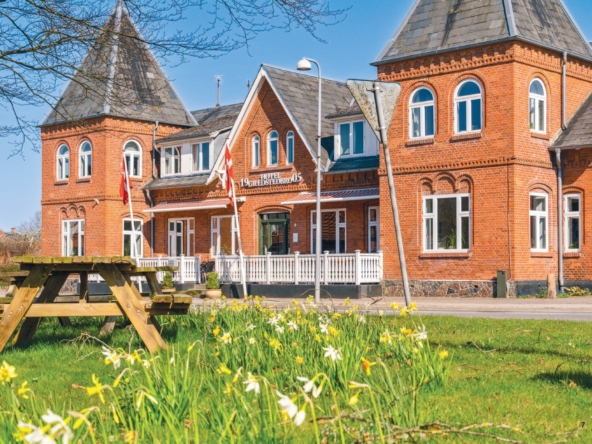 Facaden af Gredstedbro Hotel, bygget i 1905, med traditionel rød mursten og tårndetaljer