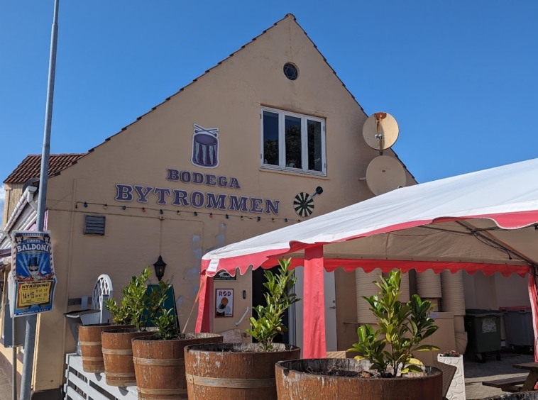 Facade af Bytrommen Bodega med udendørs siddepladser under telt i Nykøbing Sjælland