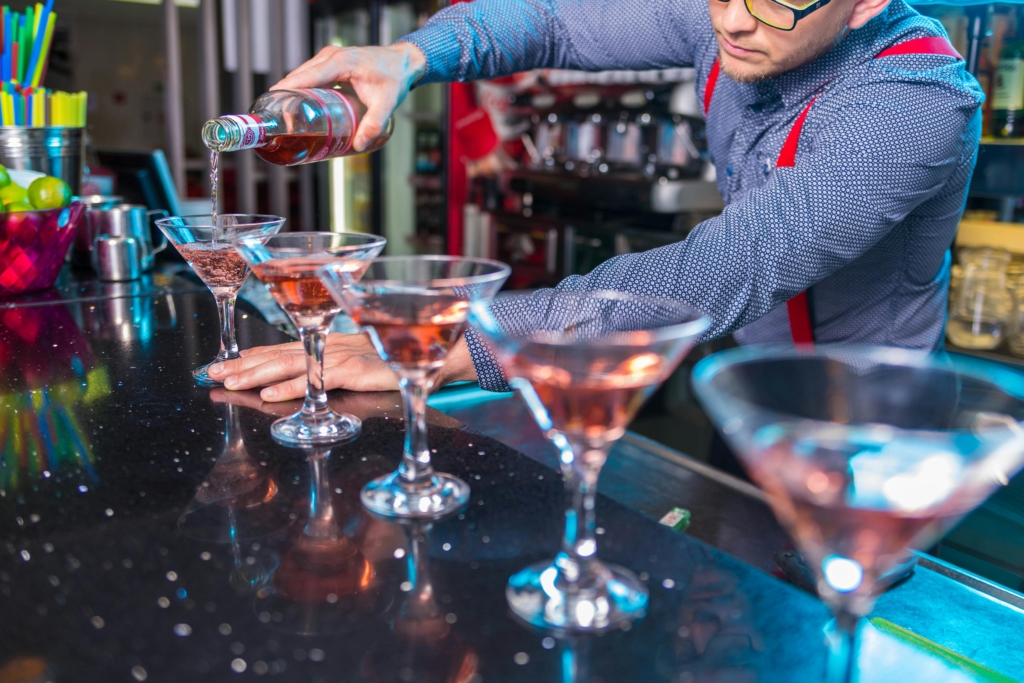 Bartender serverer cocktails – bliv bar- eller natklubejer med REKOM